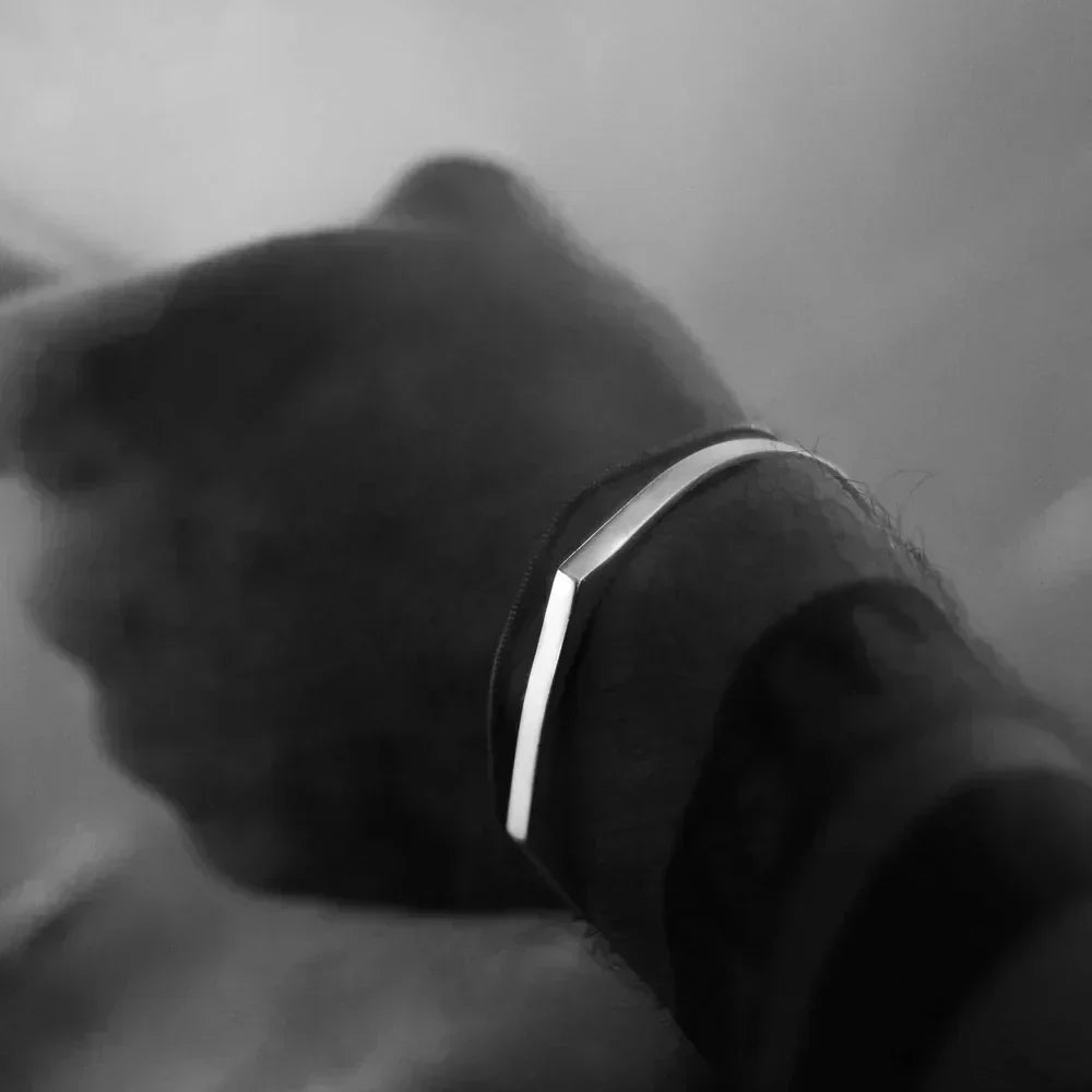 Angular open cuff bracelet worn on the wrist, black and white