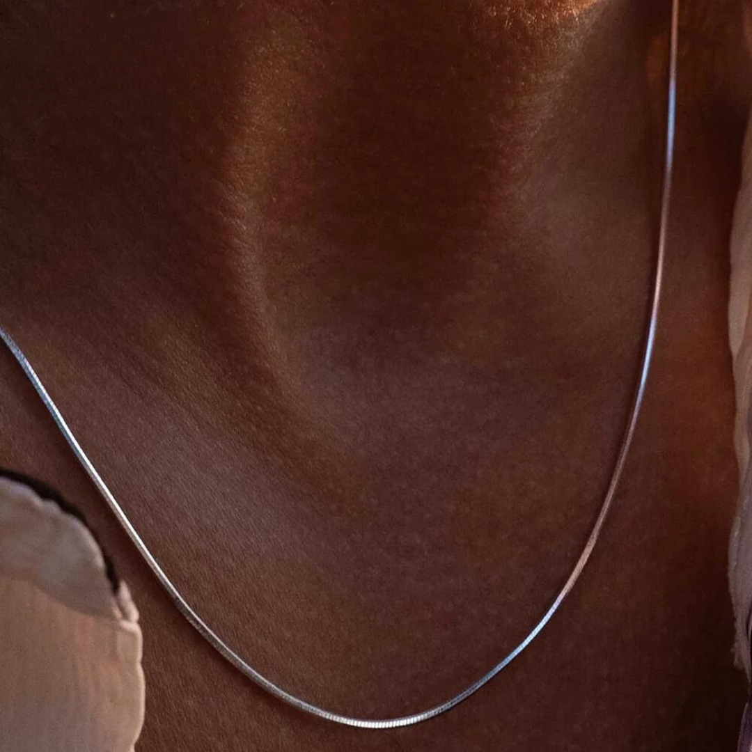 Flat herringbone chain necklace worn on the neck