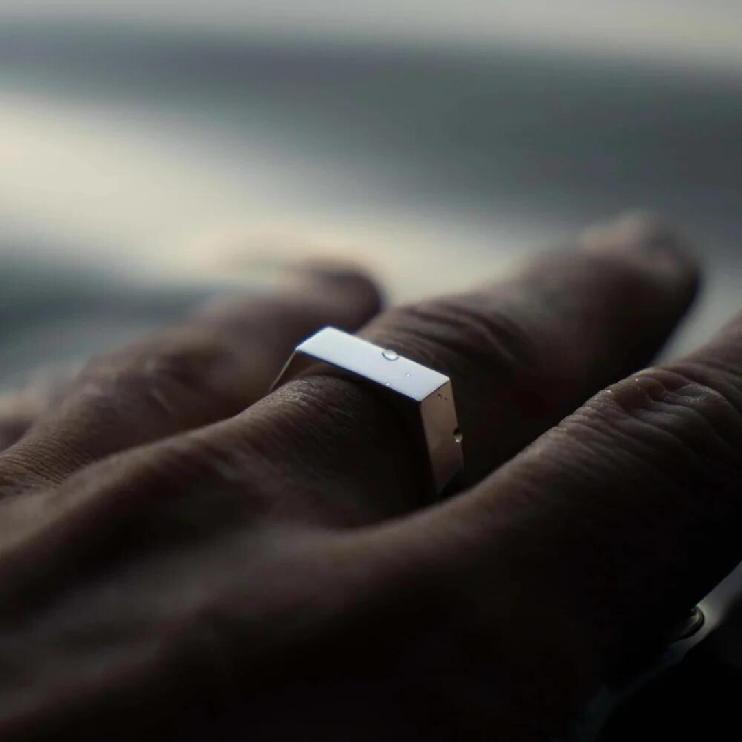 Flat-top signet ring worn on a finger