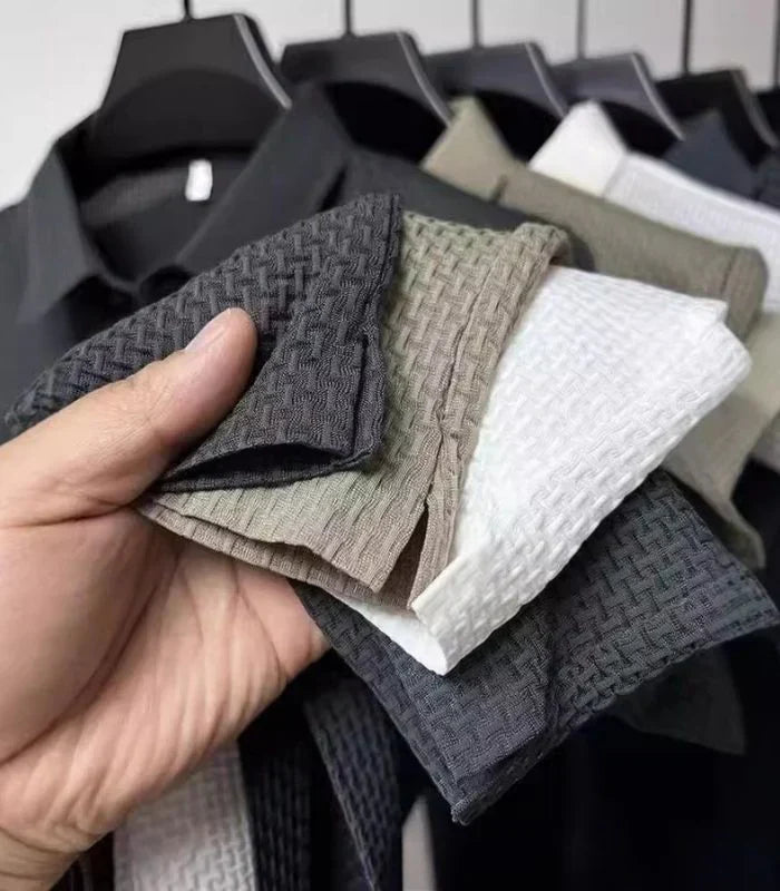 Hand holding basketweave knit polo shirts in several colors