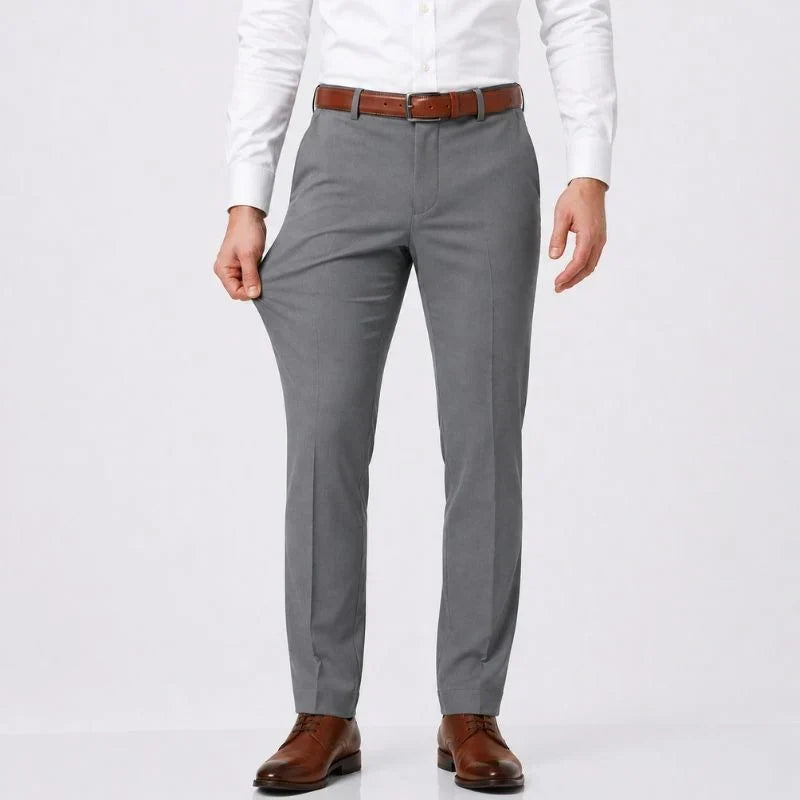 Gray slim-fit stretch dress pants with a white shirt and brown belt, front view