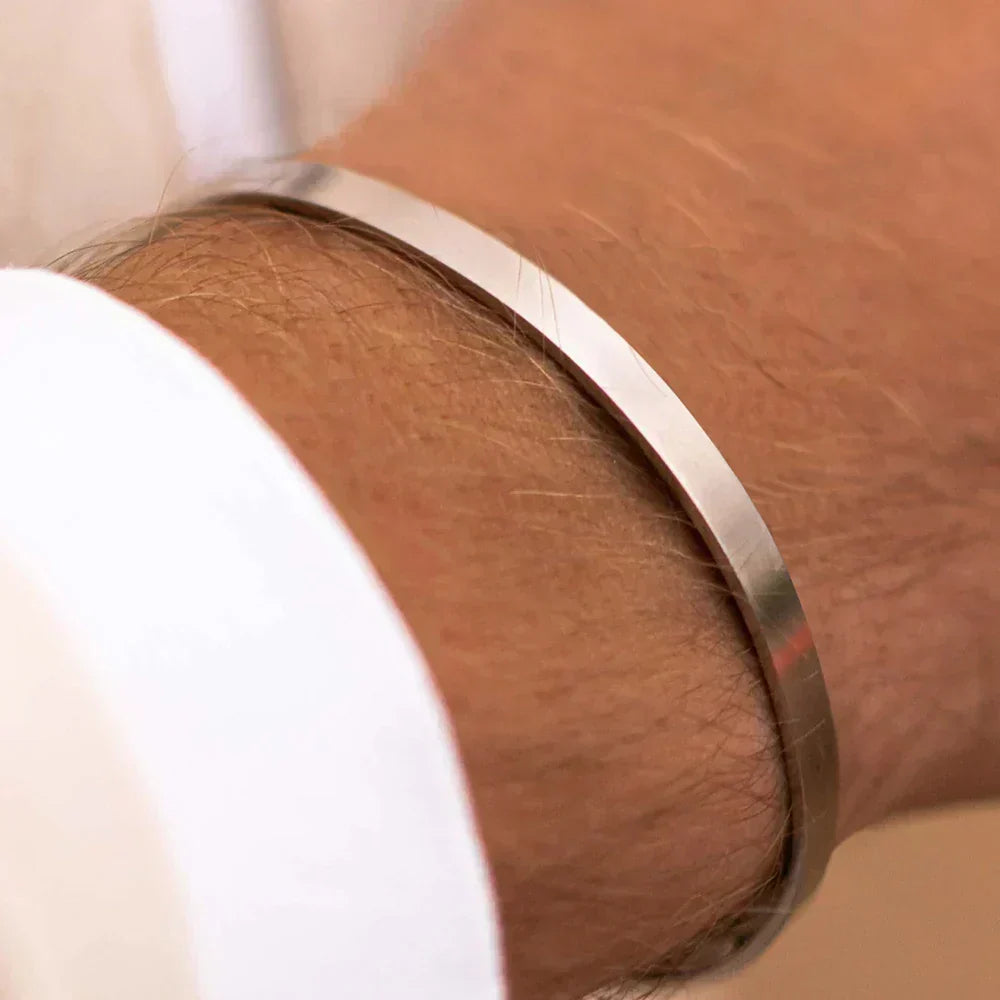 Slim open cuff bracelet worn with a white shirt cuff