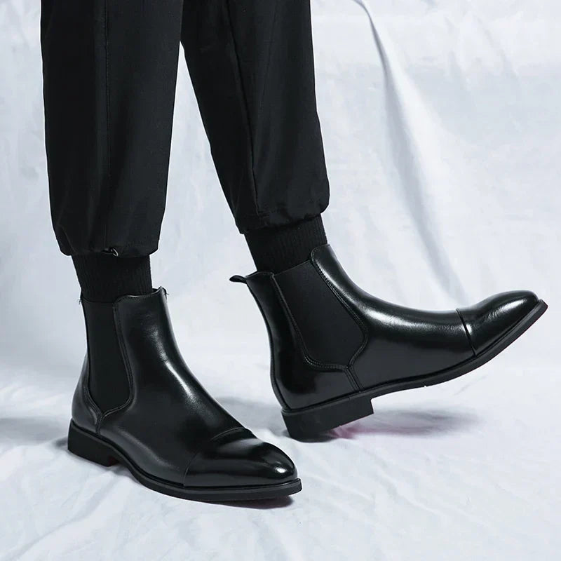 Black cap-toe Chelsea boots worn with black trousers