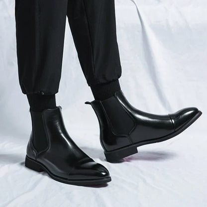 Black cap-toe Chelsea boots worn with black trousers