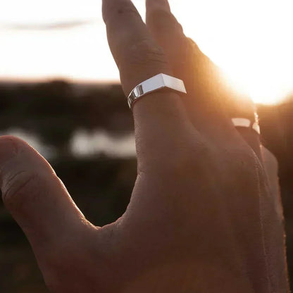 Flat-top signet ring worn against the sunset