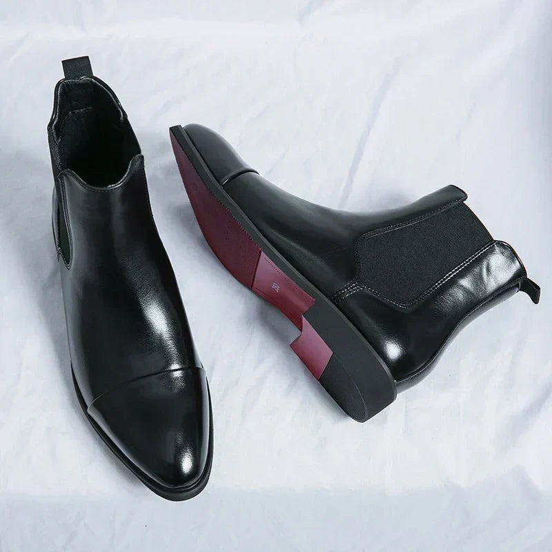 Black Chelsea boot seen from above beside a boot lying on its side