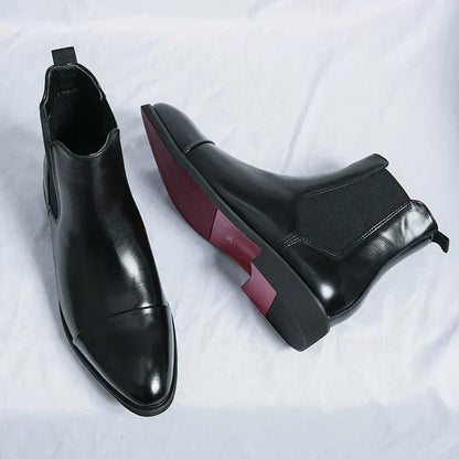 Black Chelsea boot seen from above beside a boot lying on its side
