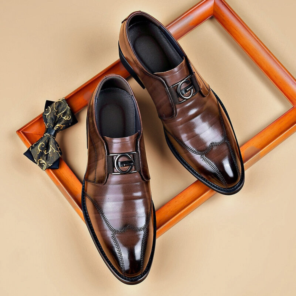 Brown wingtip bit loafers on a beige background