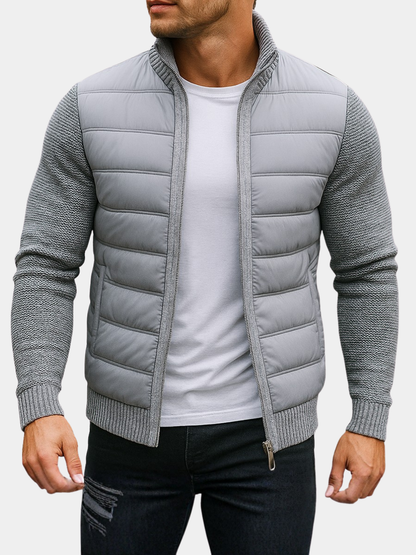 Man wearing a light gray quilted hybrid jacket with knit sleeves, front view