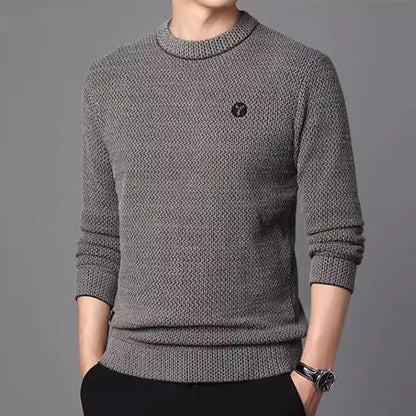 Gray textured crew neck sweater worn with dark trousers