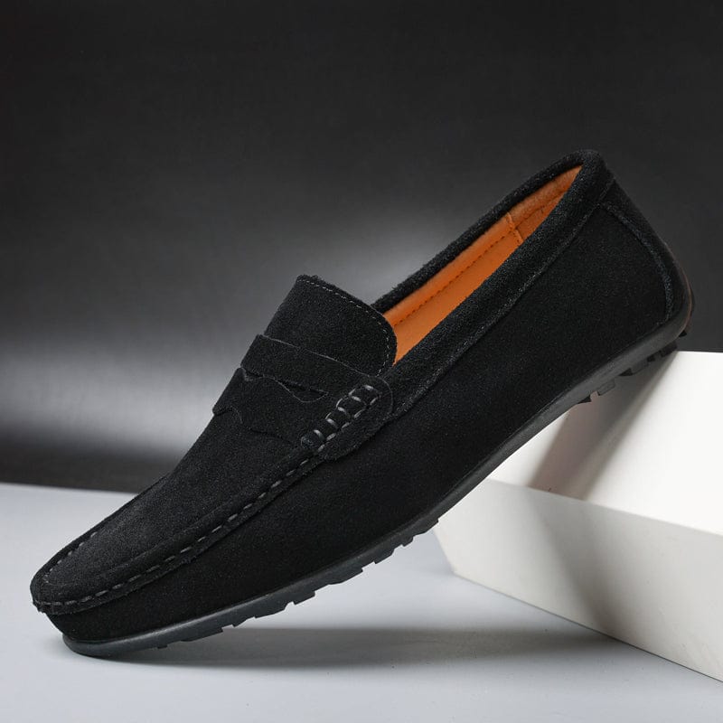 Black suede penny loafer showing the rubber nub outsole